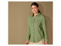 Eine Frau trägt eine grüne Bluse mit langen Ärmeln.