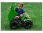 Kleiner Junge in blauem Shirt und Brille spielt mit grünem Spielzeug-LKW auf Gras.