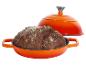 Sauerteigbrot in orangefarbenem Gusseisentopf mit Deckel.