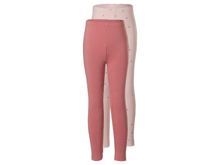 Zwei Kinderleggings, eine unifarben rosa und eine hellrosa mit Punkten.