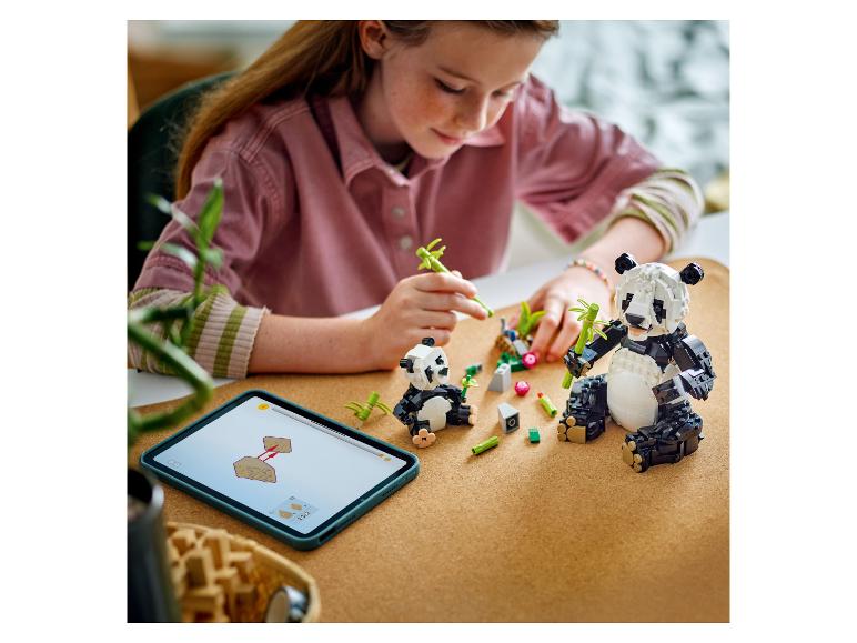 Ein Mädchen baut LEGO Pandas mit digitalen Anleitungen auf einem Tablet.