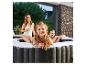 Eine Familie entspannt im Home Deluxe Outdoor-Whirlpool Drop auf einer Terrasse.