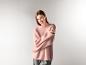 Eine lächelnde Frau in einem rosa ESMARA Mohair-Mix-Premium-Pullover und einer grauen Hose.