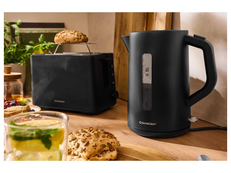 Schwarzer SilverCrest Wasserkocher und Toaster mit Frühstück auf einem Holztisch.