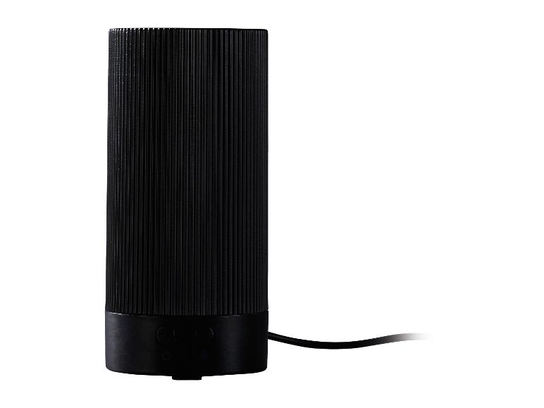 Schwarze zylindrische Tischlampe mit gerippter Textur und Bedienelementen am Sockel.