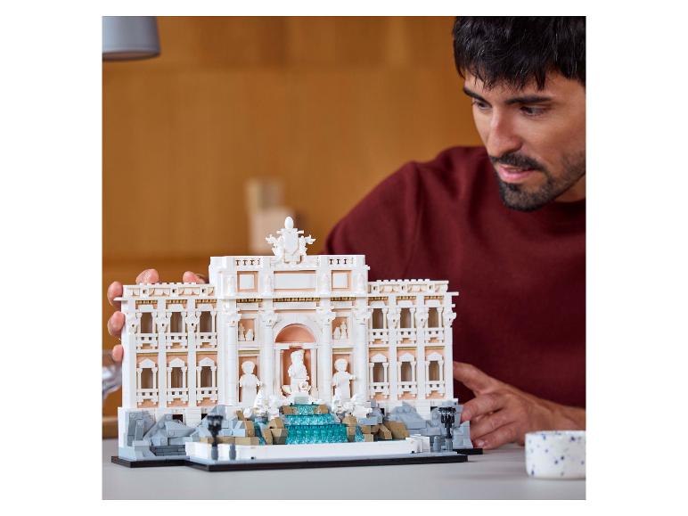 Mann bewundert ein detailliertes Trevi-Brunnen-Modell aus Bausteinen.