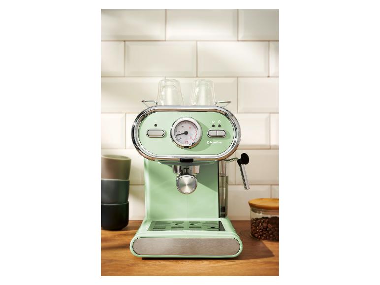 Mintgrüne Espressomaschine mit Gläsern auf einer Holztheke.
