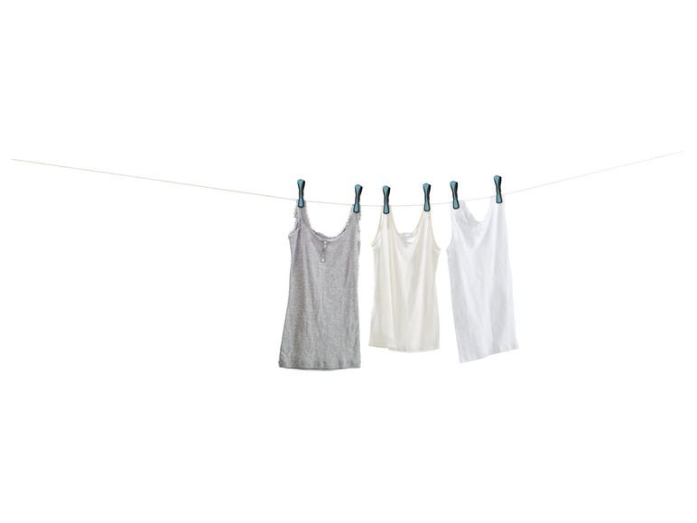 Drei Tanktops hängen zum Trocknen auf einer Wäscheleine.