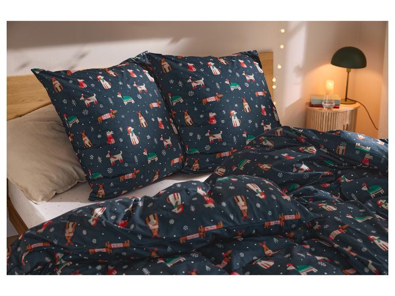 Bettwäsche mit Weihnachtshunde- und Rentier-Print in einem gemütlichen Schlafzimmer.