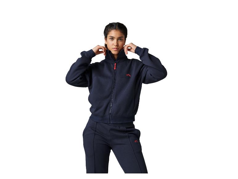Frau in einem marineblauen Trainingsanzug mit Reißverschlussjacke und passender Jogginghose.