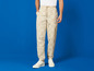 Beige Hose mit Lidl-Print und weiße Sneaker.