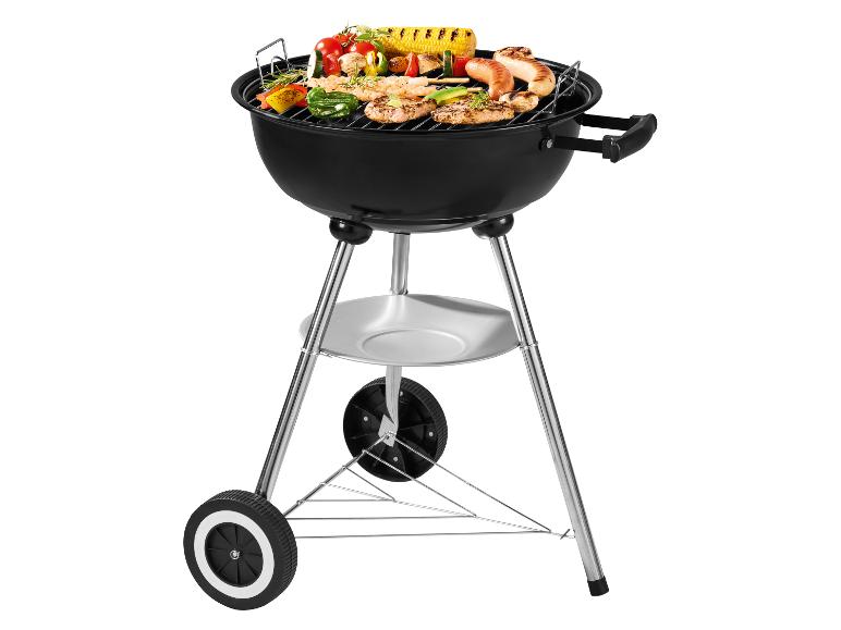 Schwarzer Holzkohlegrill mit Rädern, gefüllt mit gegrilltem Fleisch und Gemüse.