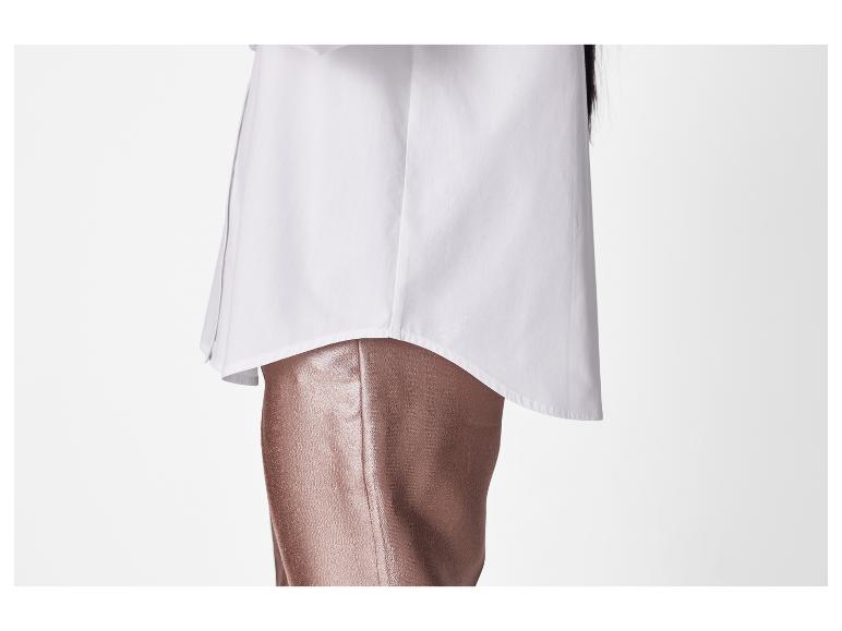 Ein weißes Hemd und bronzefarbene Hosen.