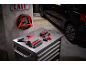 Tragbarer Starthilfe und Batterieladegerät auf einem Metallschrank in einer Garage.