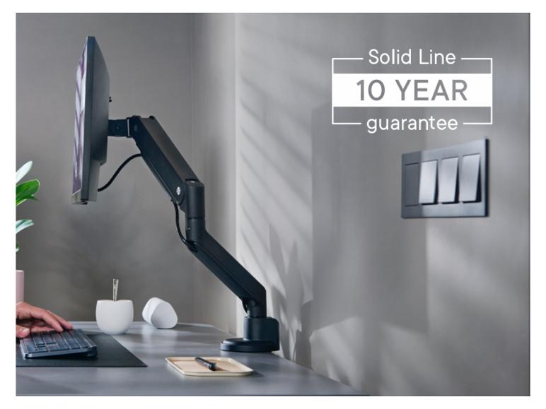 Monitorarm mit 10 Jahren Garantie, Tastatur und Schreibtischzubehör in einem modernen Büro.