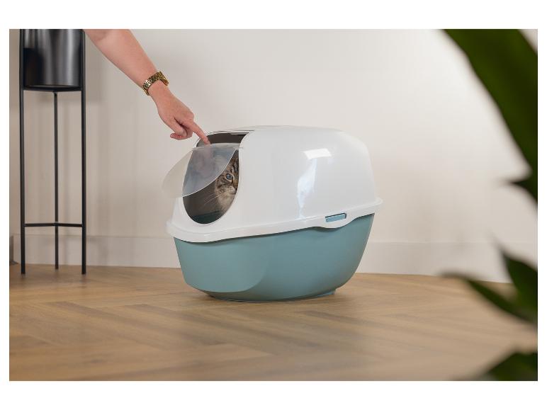 Katze in einer geschlossenen Katzentoilette, eine Hand öffnet die Tür.