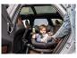 Ein Baby sitzt in einem drehbaren Autositz auf dem Rücksitz eines Autos.