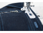 Nähmaschine mit dunklem Jeansstoff und Reißverschluss