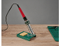 Lötkolben mit Ständer und Schwamm, sowie Silikonmatte auf einem Holztisch.