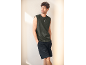 Mann in dunkelgrünem, ärmellosem T-Shirt und schwarzen Shorts.