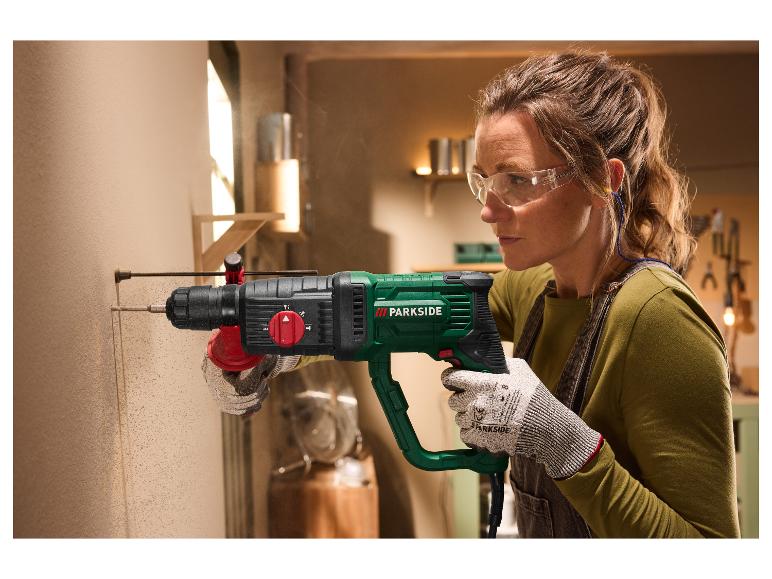 Frau mit Schutzbrille und Handschuhen bohrt mit einem PARKSIDE Bohrhammer in eine Wand.