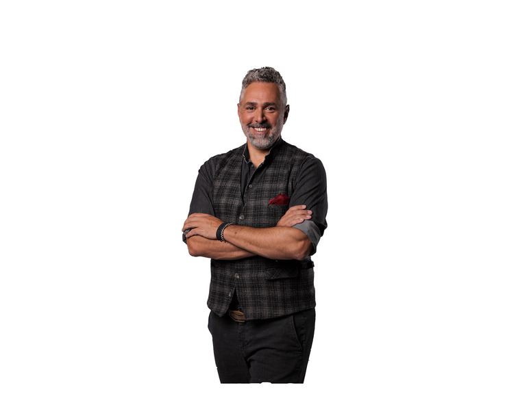 Ein Mann trägt ein dunkelblaues Hemd mit einer grauen Weste.