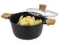 Schwarzer Kochtopf mit Holzgriffen, Glasdeckel und geschälten Kartoffeln
