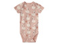 Ein rosa Baby-Body mit einem Druck von Schwänen und Blumen.