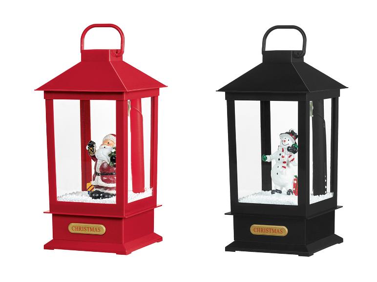 Zwei Weihnachtslaternen, eine rote mit Weihnachtsmann, eine schwarze mit Schneemann.