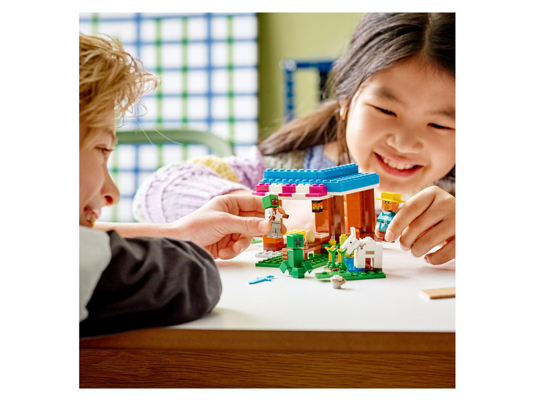 Zwei Kinder spielen mit einem LEGO Minecraft Farmset.