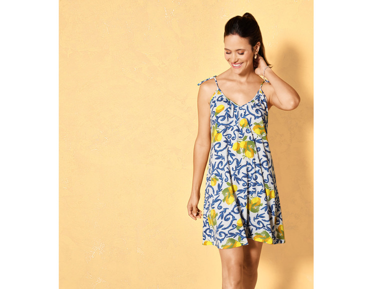 Eine Frau in einem Sommerkleid mit Zitronenmuster.