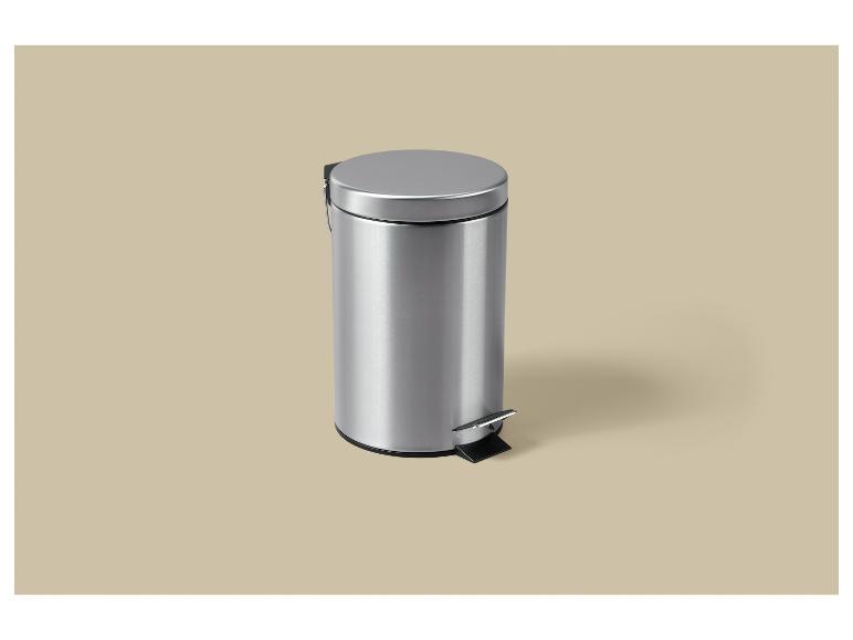 Ein silberner Treteimer mit Deckel auf beigem Hintergrund.