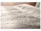Gesteppte LIVARNO home Tagesdecke mit Wellenmuster auf einem Bett.