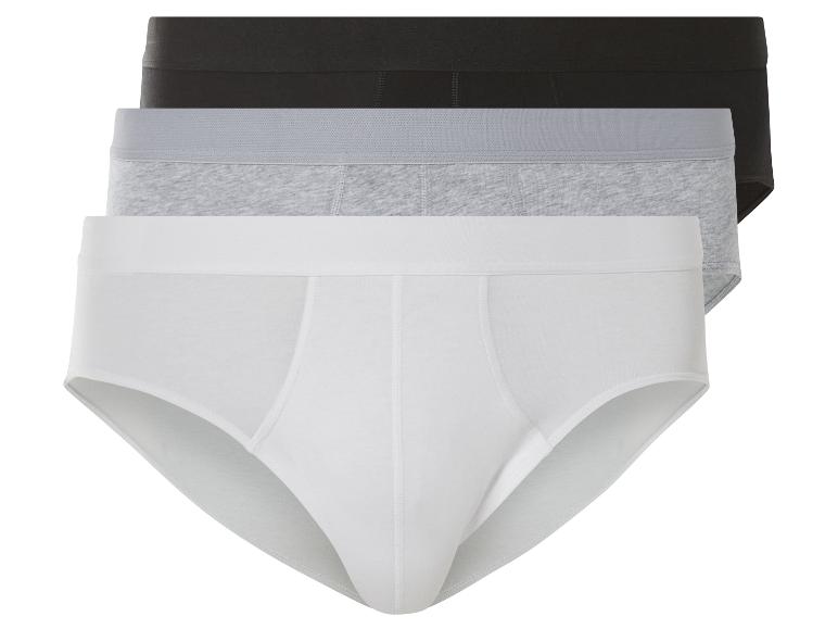 Drei Paar Boxershorts in Weiß, Grau und Schwarz.
