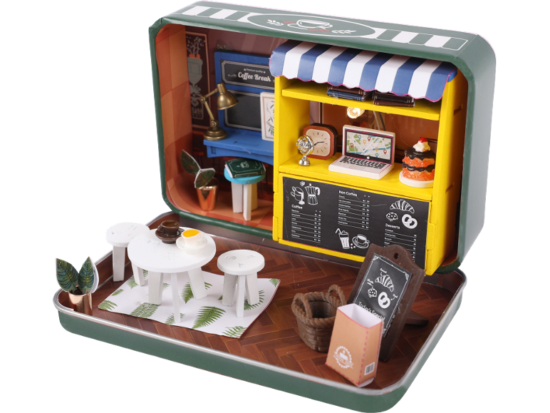 Miniatur-Café-Diorama in einer Blechdose, mit Café-Theke, Außensitzplätzen und Speisekarte.