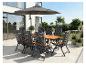 Garten-Essgruppe mit Holztisch, Klappstühlen und Sonnenschirm auf einer Terrasse.