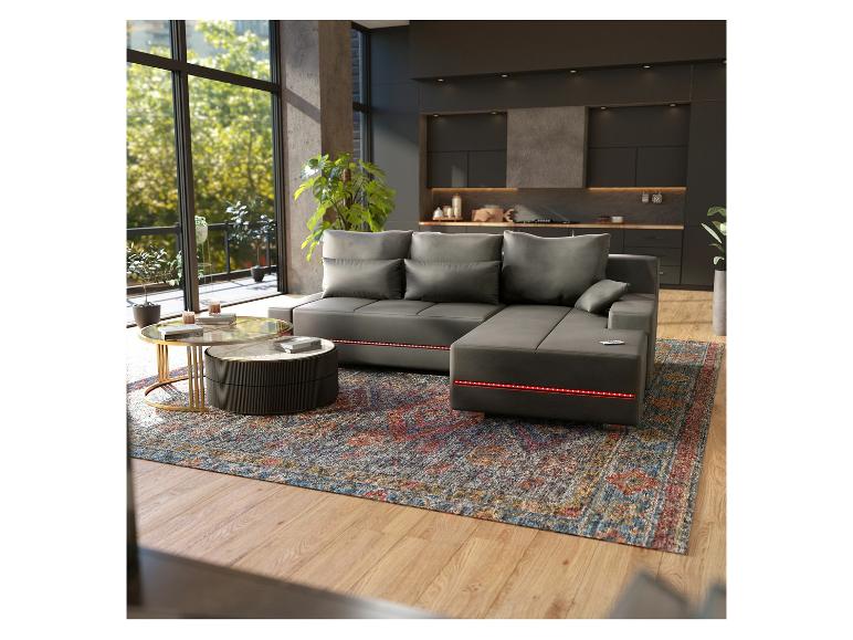 Ein graues Ecksofa mit LED-Beleuchtung, ein runder Couchtisch und ein Teppich in einem modernen Interieur.