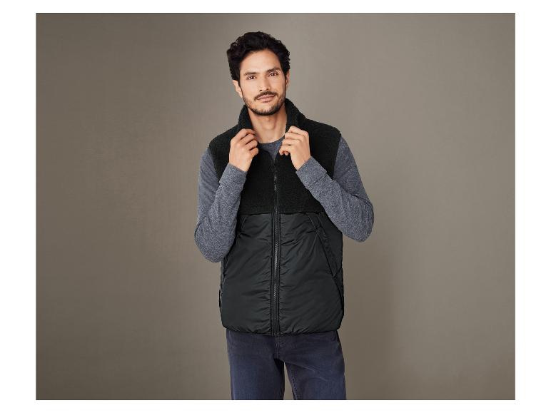 Mann trägt eine schwarze Fleece-Weste mit Kapuze.