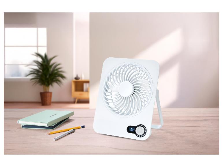 Weißer Tischventilator mit 60° Digitalanzeige auf einem Holztisch mit Notizbüchern und Stiften.