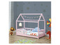Ein rosafarbenes Kinderbett in Form eines Hauses mit Himmelbett.