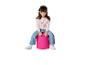 Lächelndes kleines Mädchen sitzt auf einem pinken Pouf, trägt einen pinken Einhorn-Pullover und Jeans.