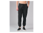 Herren-Jogginghose in Schwarz mit Kordelzug und schwarzen Sneakern.