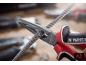 Spitzzange schneidet ein Metallkabel, kleine Metallsplitter fliegen herum.