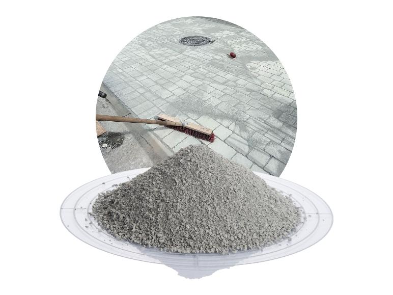 Fugensand für Pflastersteine auf einem transparenten Teller, im Hintergrund eine gepflasterte Fläche.