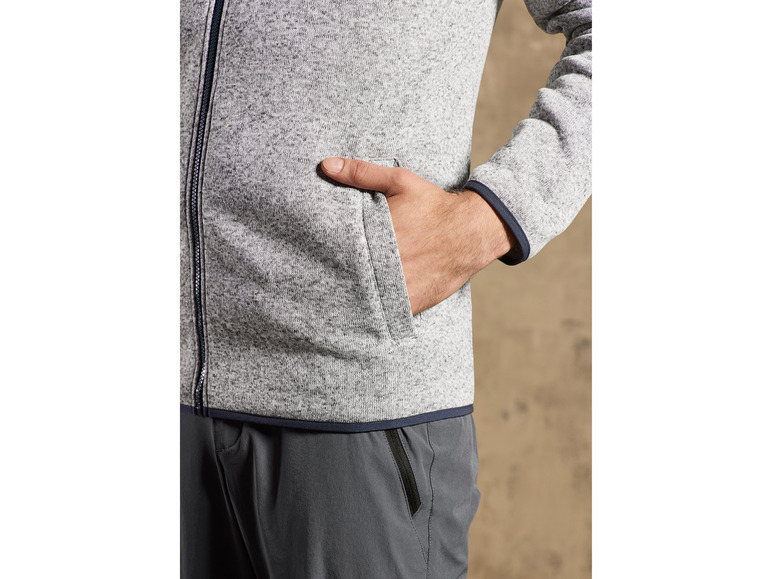 Eine graue Fleecejacke mit Reißverschluss und dunkelgraue Hose.