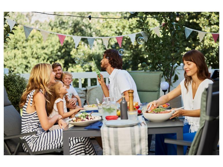 Familie und Freunde genießen eine Gartenparty mit Essen im Freien.