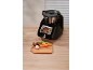 Schwarze multifunktionale Küchenmaschine mit Bildschirm, der ein Rezept anzeigt, daneben ein Schneidebrett mit Gemüse.