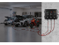 Batterieladegerät an der Wand lädt zwei Autos und ein Motorrad in einer Garage