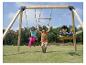 Kinder spielen auf einer Holzschaukel mit Ringen und Sitz, auf einem grünen Feld.