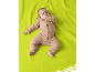 Baby in einem beigen Kapuzenoverall, liegend auf einer lindgrünen Decke.